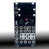 Front view of a dark modular synth panel with many 1/4-inch audio jacks arranged in rows, labeled with inputs and outputs (IN/L, IN/R, OUT, A/B, X/Y, USB, HOST) and several knobs nearby.